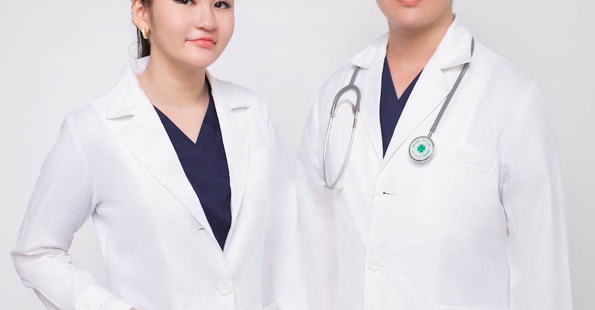 Photo by Tran Nhu Tuan Portrait of male and female healthcare professionals in studio setting, wearing white coats.