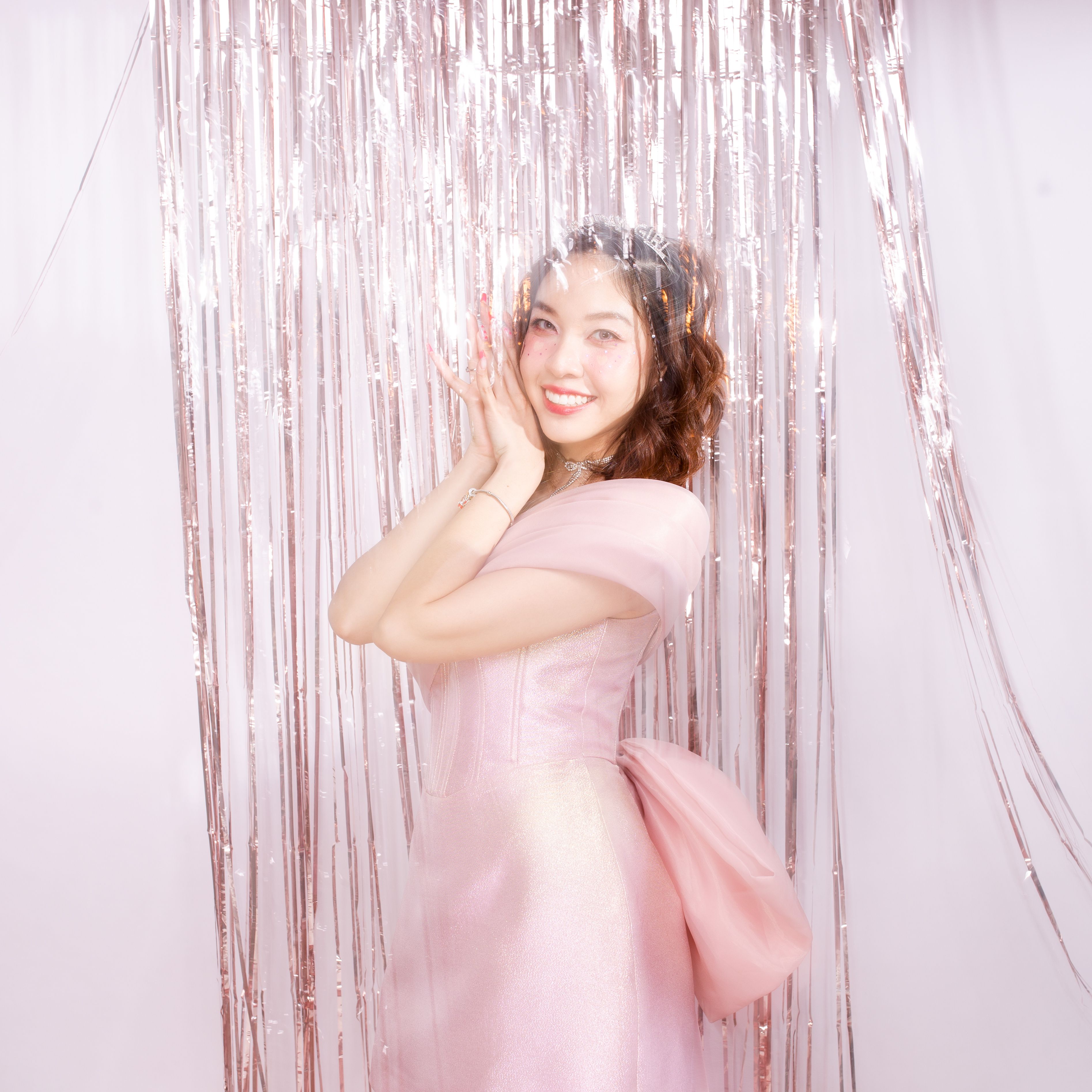 Young Woman in a Pink Dress on the Background of Tinsel 
