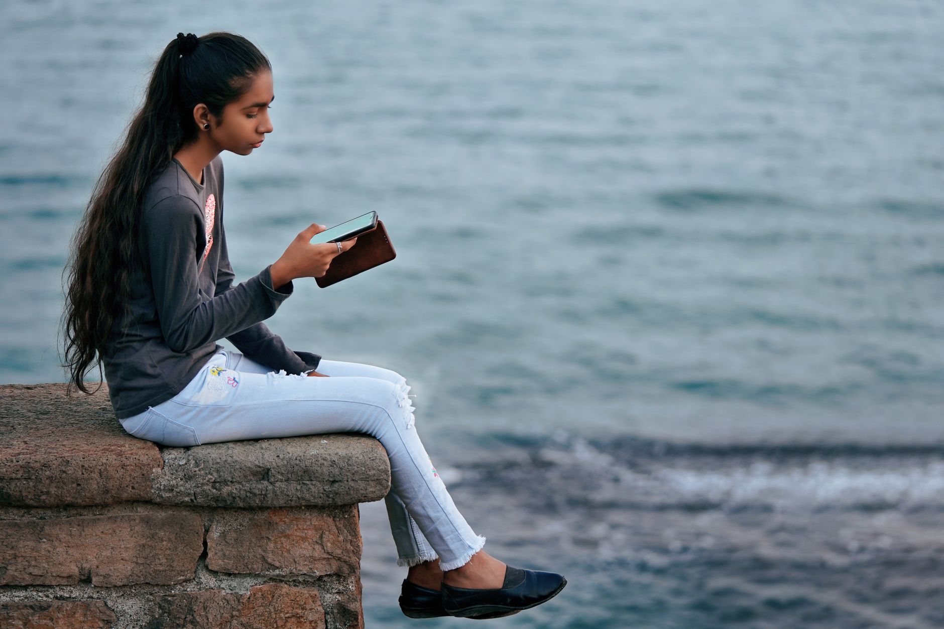 Person meditating in a quiet room in India with a phone placed face-down nearby