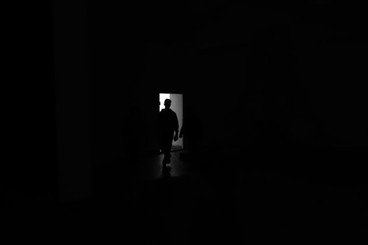 Silhouette Of A Man Standing In The Door 