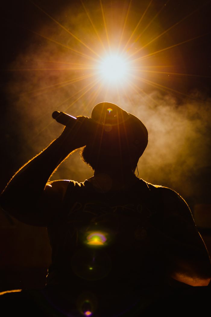 Silhouette of a singer under a bright stage light — photo by Faruk Tokluoglu on Pexels