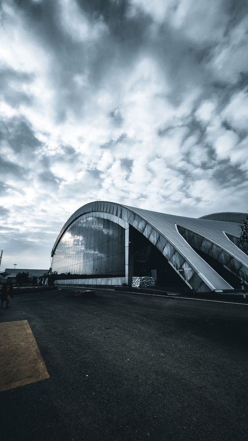 Free Dynamic shot of a modern building with a dramatic cloudscape in Badgam. Stock Photo