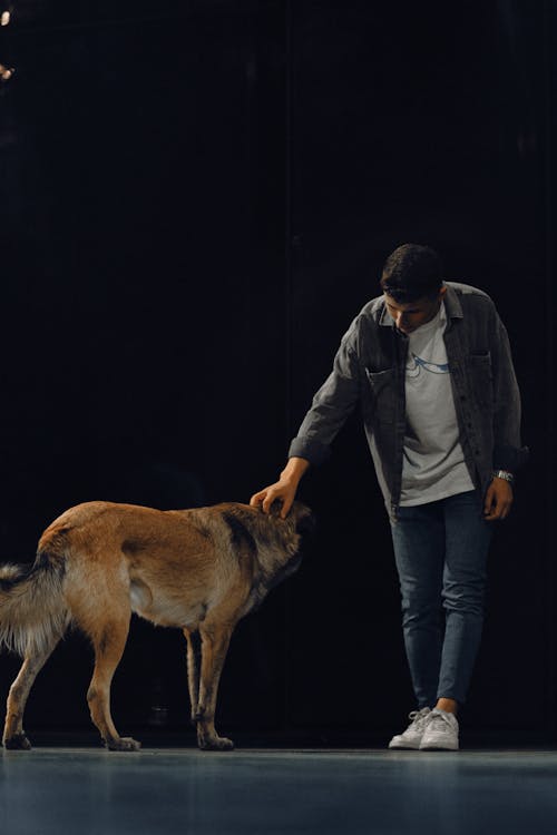 Photo of Man Petting a Dog