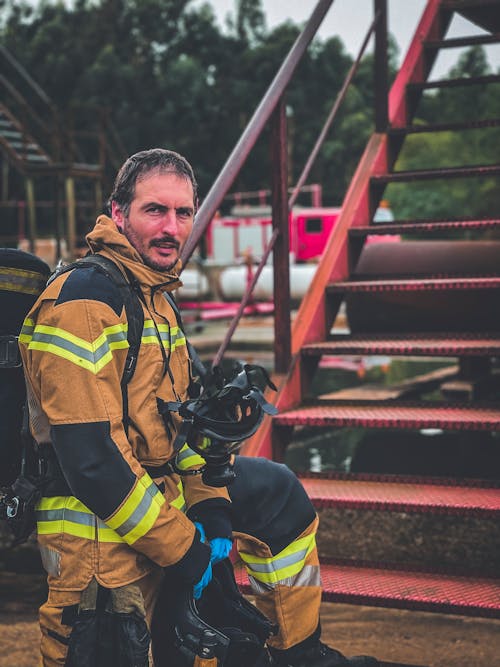 A Man in Bunker Gear Standing Near the Metal Stairs