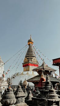 Swayambhu Stupa with prayer flags in Kathmandu, Nepal, showcasing Buddhist architecture.