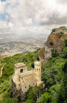 Stunning aerial shot of Torretta Pepoli castle amidst lush greenery in Sicily, Italy.