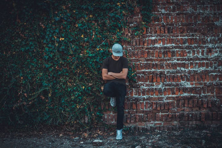 Man Leaning On Brick Wall