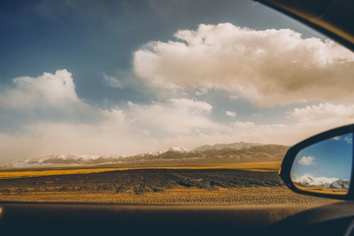 Free Dramatic landscape view of mountains and sky from inside a car, capturing a sense of adventure. Stock Photo