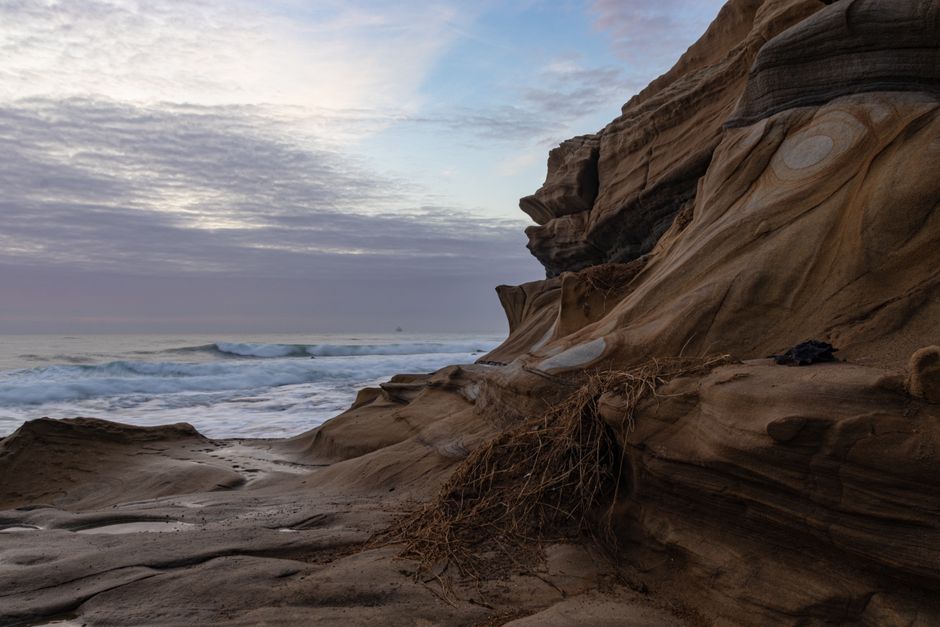 Stunning landscape of rocky coastline at Dolphin Coast, KZN during a serene sunset.