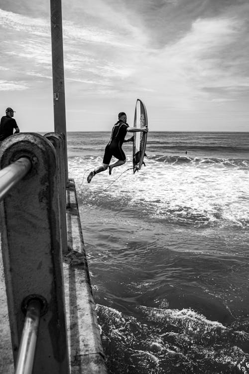 A Surfer Jumping on Water with a Surfboard