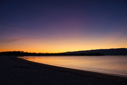 Serene sunrise at Stamford beach with vibrant sky reflecting over calm waters, creating a tranquil atmosphere.