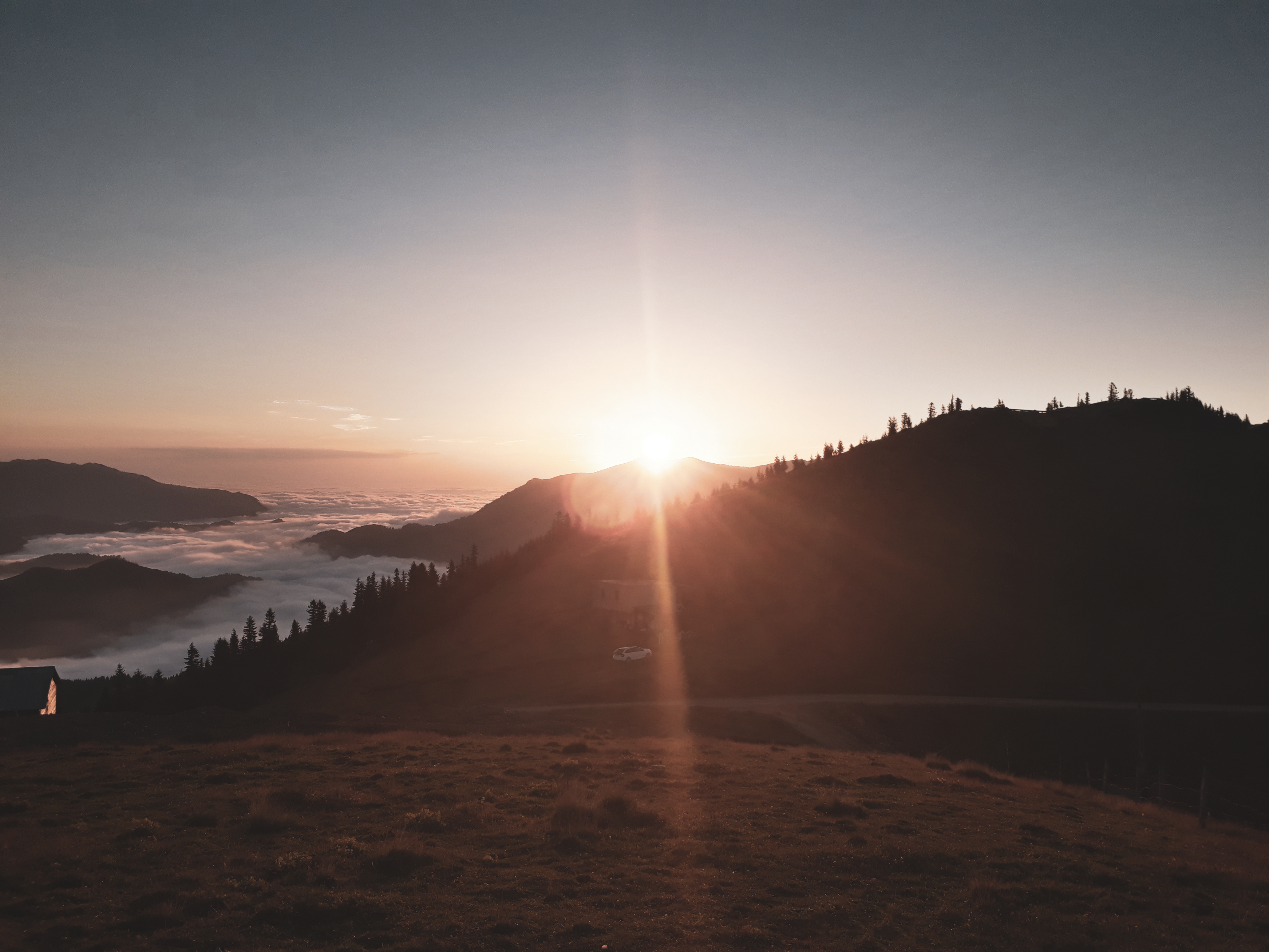 Breathtaking mountain sunset with rays of light and cloud-filled valleys.