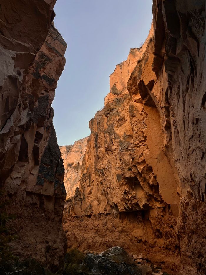 Towering sandstone canyon walls at golden hour — photo by sena çam on Pexels