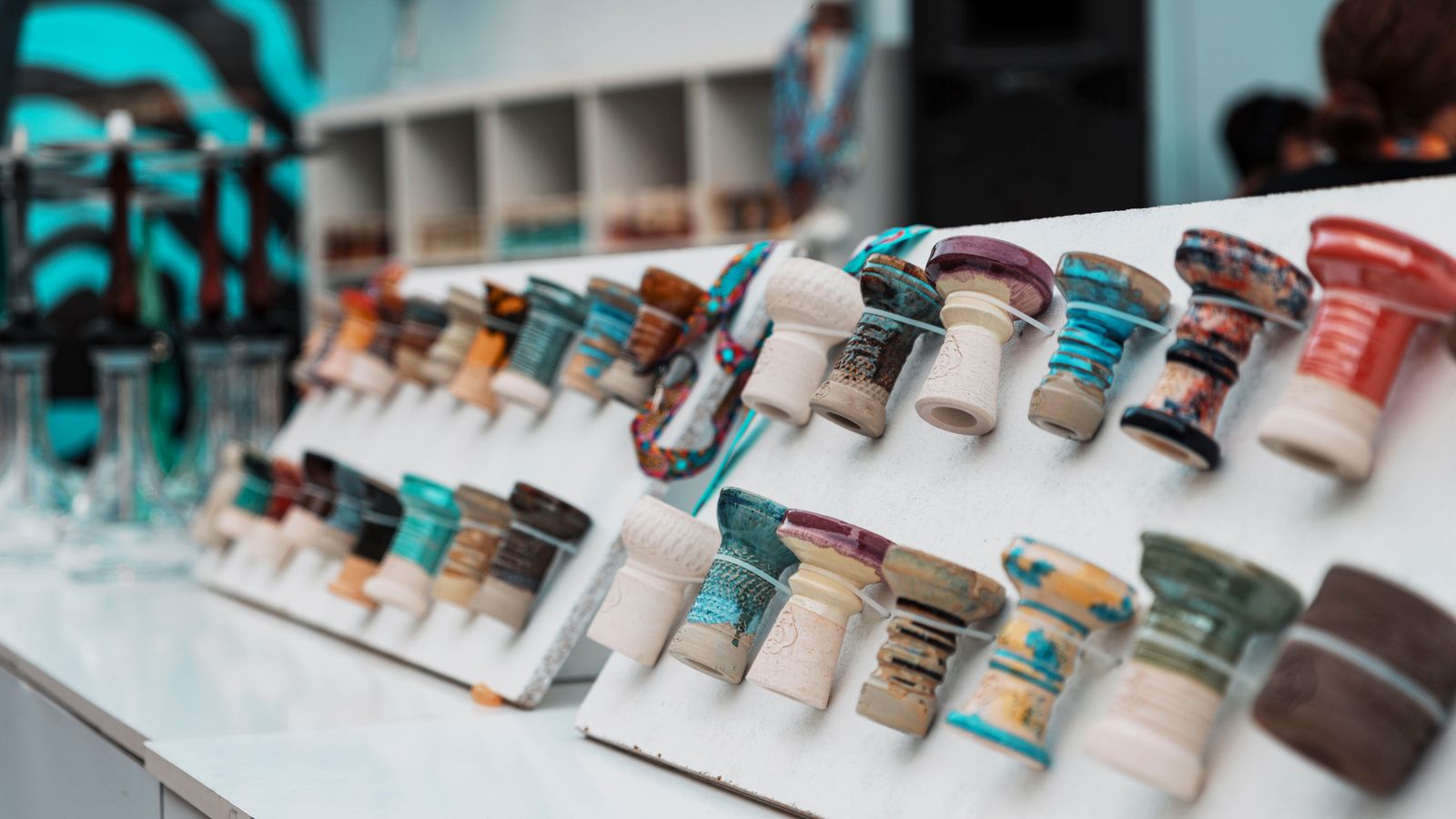 Vibrant ceramic hookah bowls on display in a modern shop setting, ideal for lifestyle imagery.