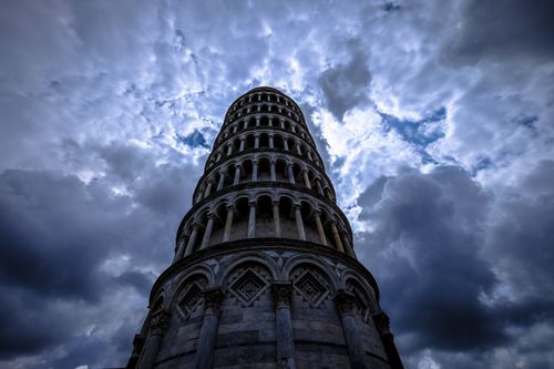 Free Striking low angle shot of the Leaning Tower of Pisa against an overcast sky. Stock Photo
