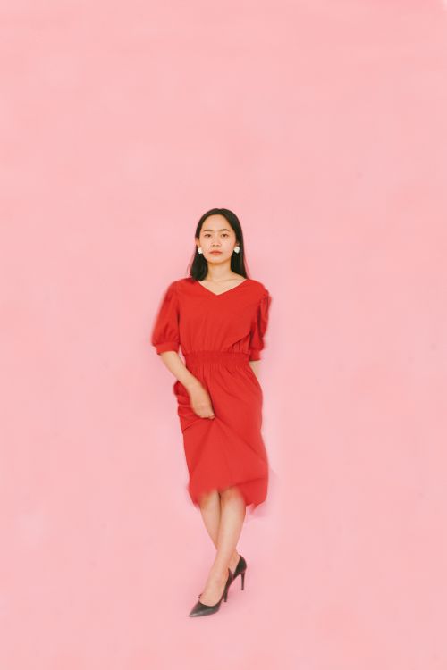 Portrait of a Woman in Red Dress against Pink Background  Free Stock Photo