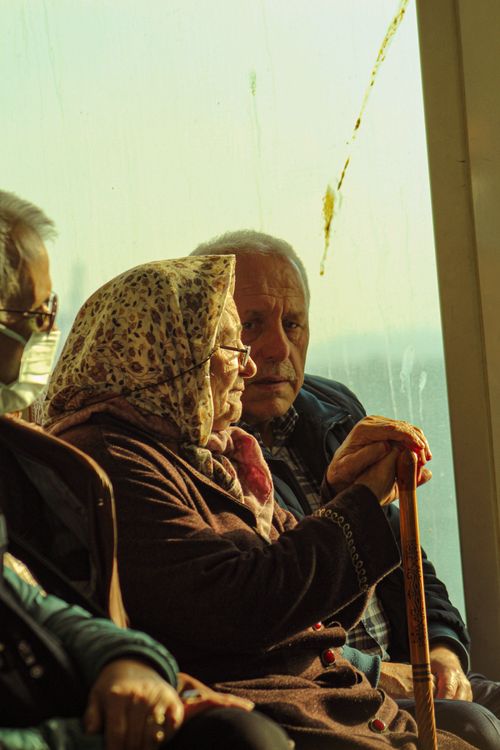 Free An elderly couple sitting together indoors, enjoying a peaceful moment in natural light. Stock Photo