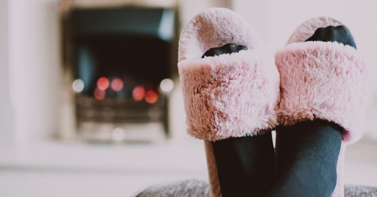 Relaxing by the fireplace with fuzzy slippers and warm socks indoors.