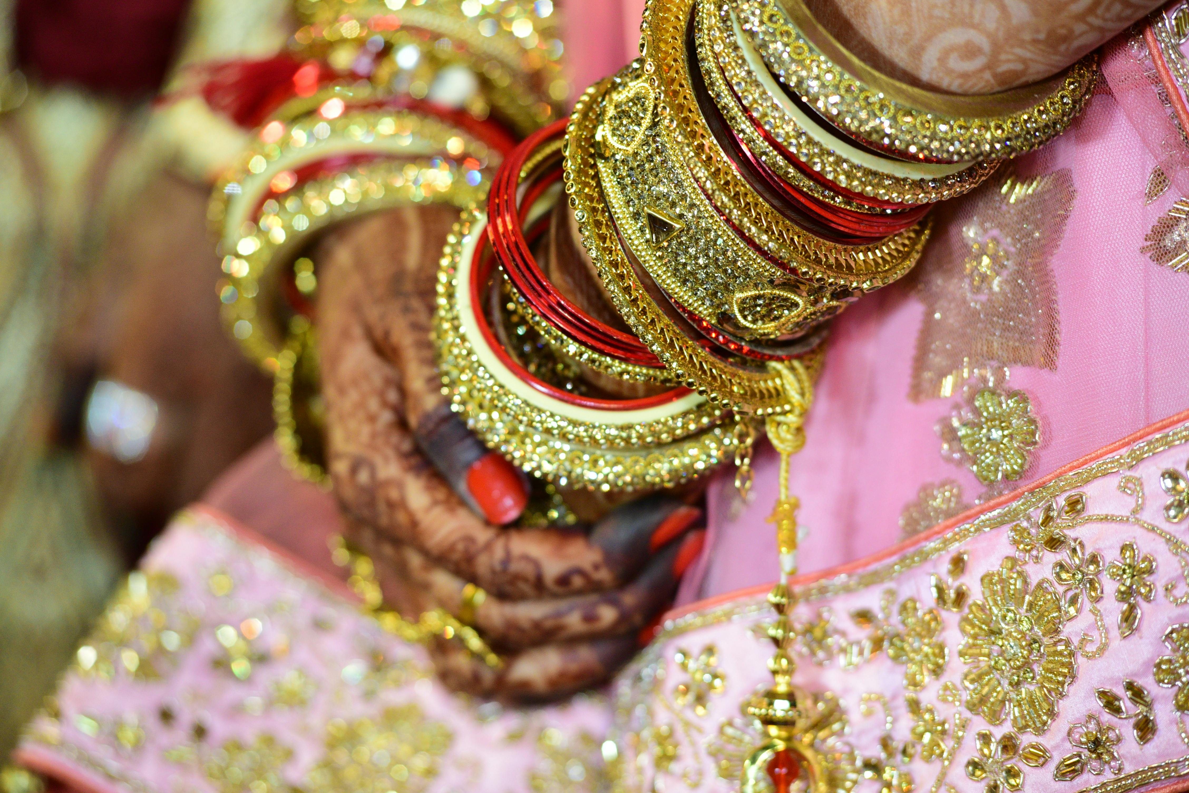 woman wearing gold colored bangle and mehndi