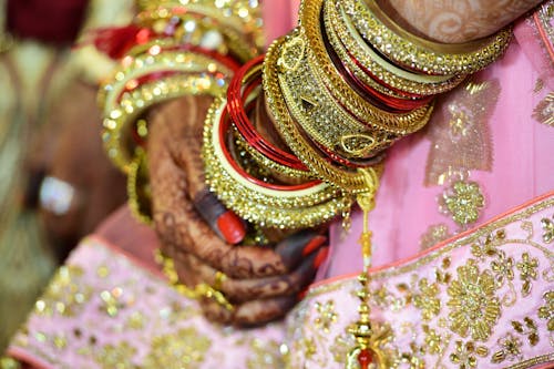 Woman Wearing Gold-colored Bangle and Mehndi
