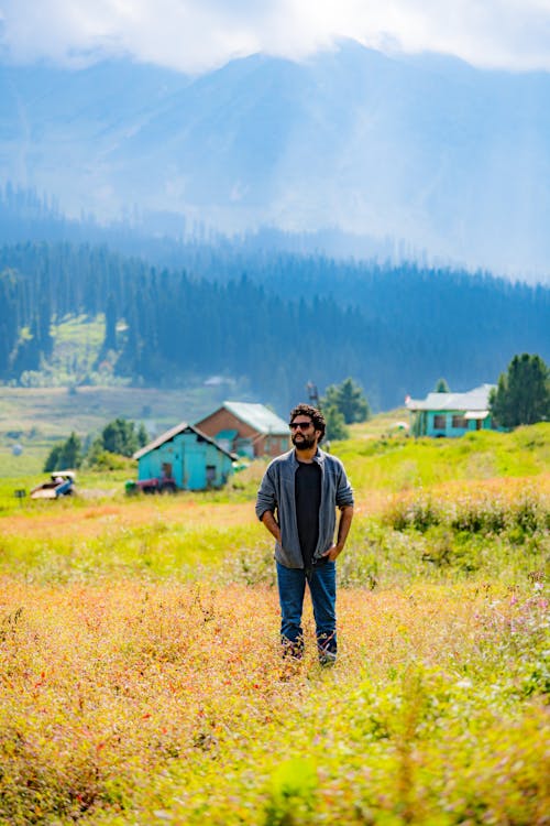 A Man Wearing Sunglasses Standing on the Grass 