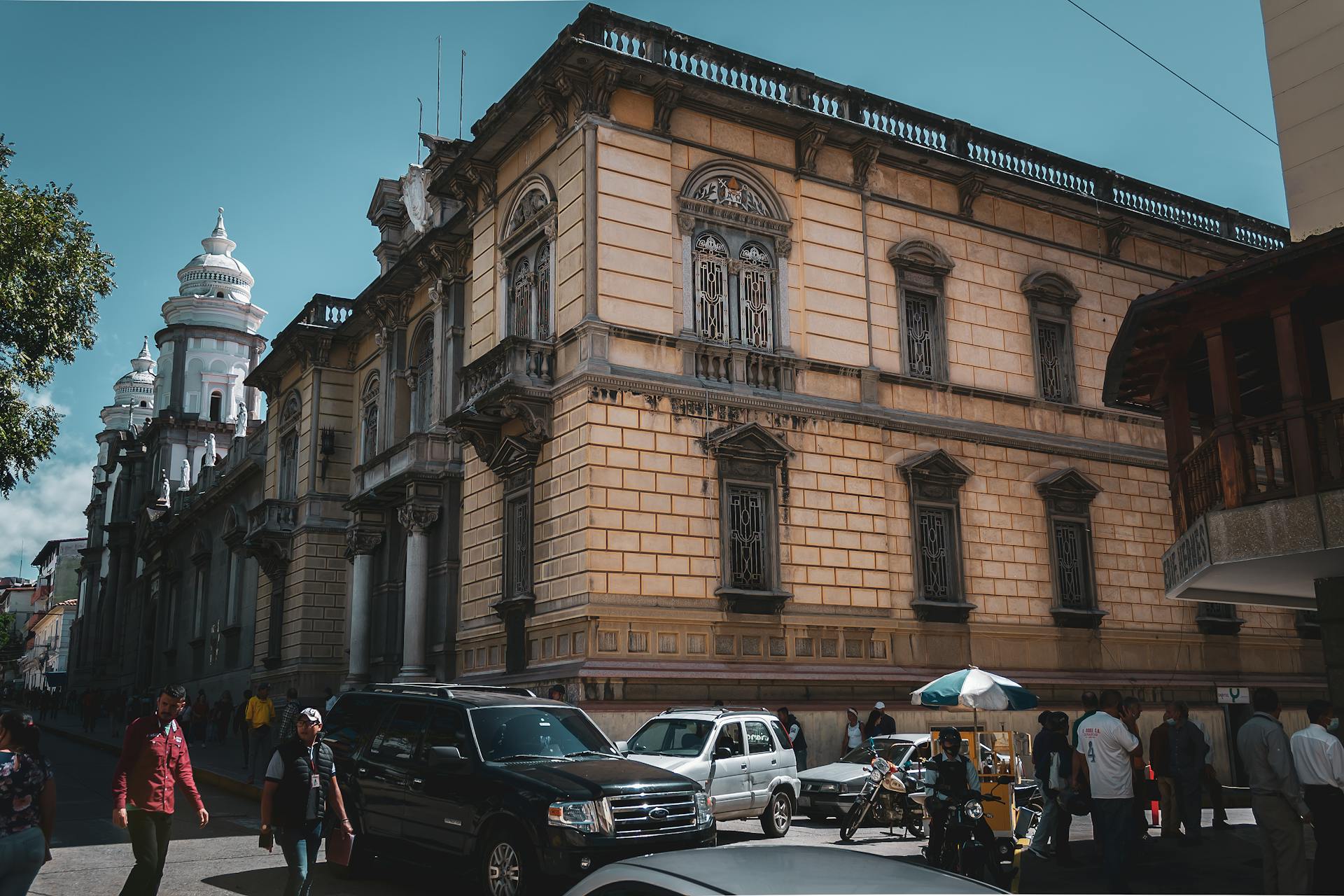 Historic colonial architecture scene from Mérida, Venezuela with bustling city life.
