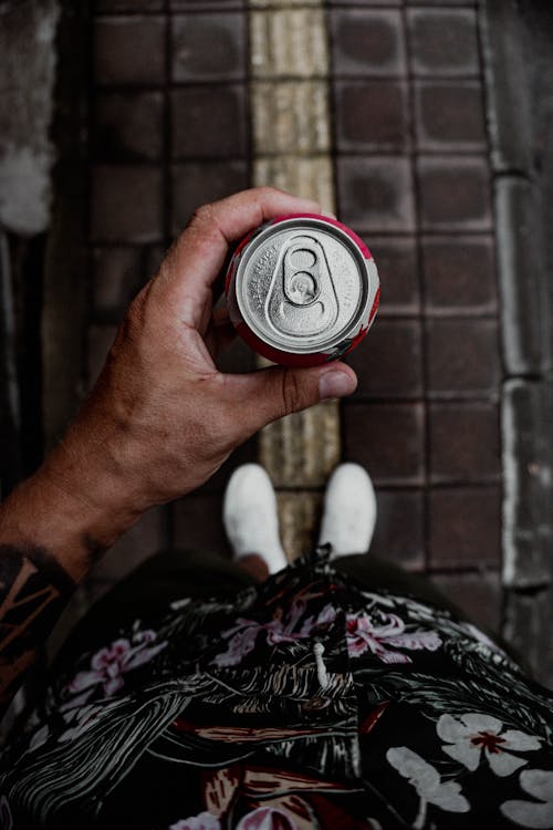 Person Holding Black and Silver Round Container