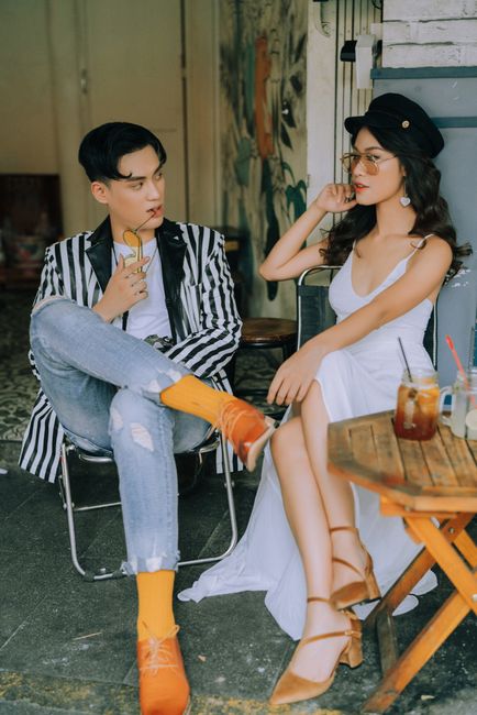 Fashionable couple enjoying drinks in a cozy Hanoi cafe setting, exuding urban charm.
