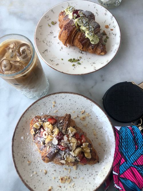 Free Top view of croissants with nuts and cream served with iced coffee on a marble table. Stock Photo