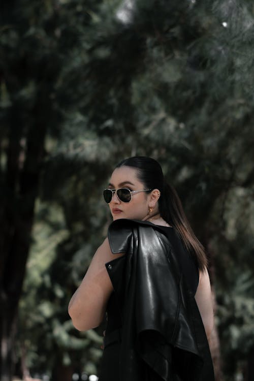 Brunette in Sunglasses Holding Leather Jacket