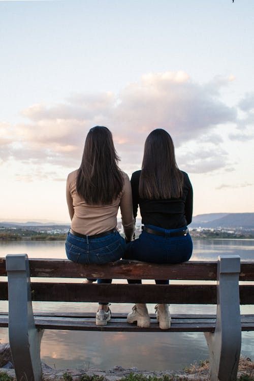 Two Brunettes on Bench over Lake at Dawn