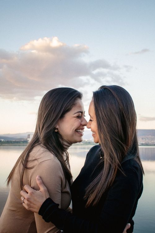 Free A joyful couple shares a tender moment by a serene lakeside, expressing love and happiness. Stock Photo