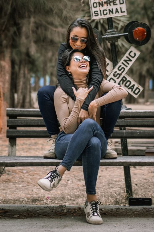 Free Joyful lesbian couple embracing on a park bench, expressing love and happiness. Stock Photo