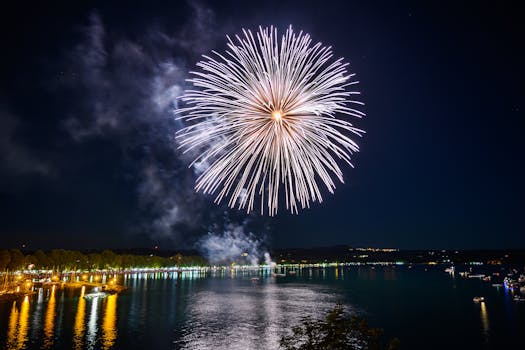 Vivid fireworks light up the night sky, reflecting on a calm lake during a festive celebration.