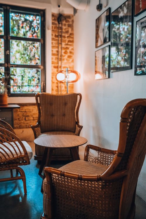 Free Warm and inviting living room featuring wicker furniture, soft lighting, and bohemian decor style. Stock Photo