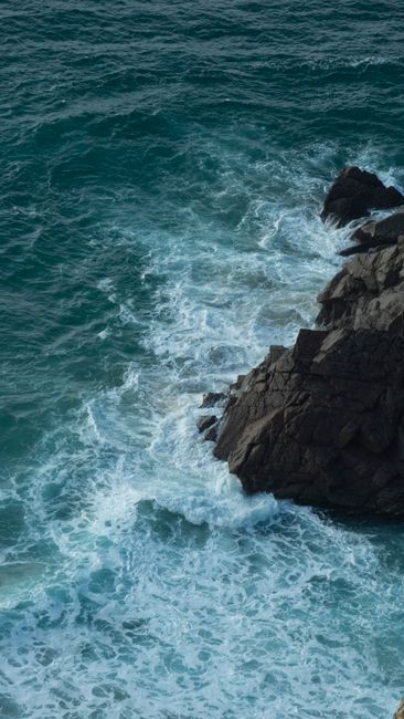 Beautiful view of ocean waves hitting rocky cliffs at Colares, Portugal. Perfect for wallpapers and nature lovers.