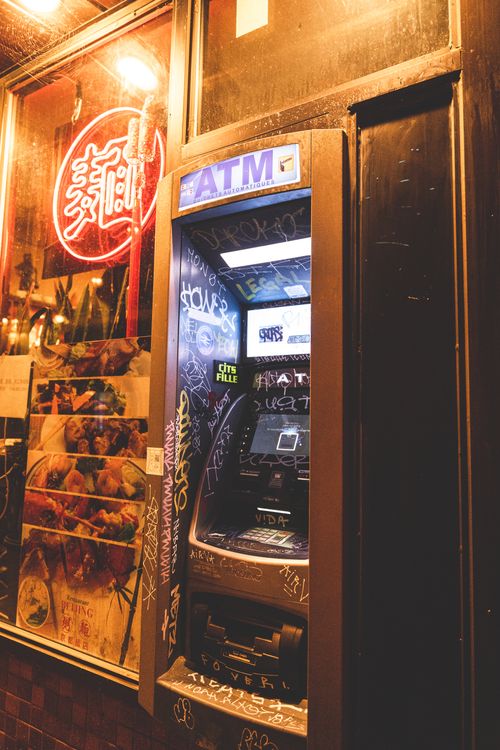 Free ATM machine with graffiti, located on a street in Montreal, Canada, captured at night. Stock Photo