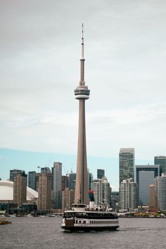 Stunning view of CN Tower with Toronto skyline and ferry on Lake Ontario, Canada.