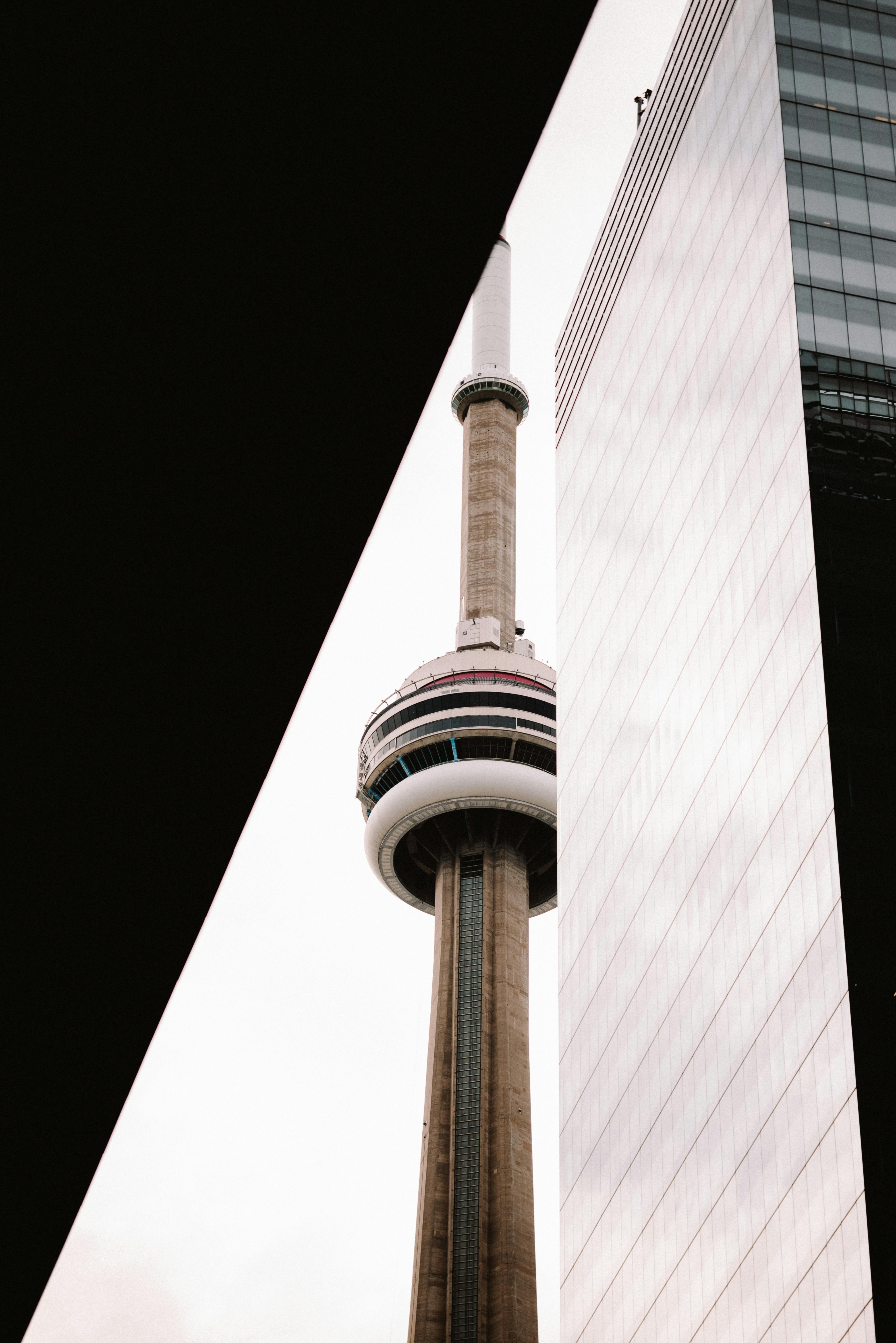 A striking view of Toronto's CN Tower framed by modern skyscraper facades.