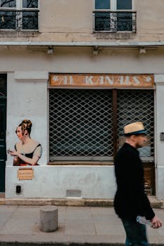 Blurred man walks past street art on a storefront in Paris, France.