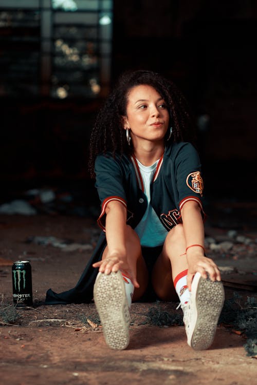 A Woman in a Black Jacket Sitting on the Ground