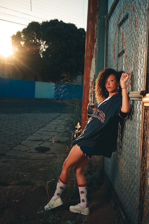 Woman Leaning on Chain Link Fence