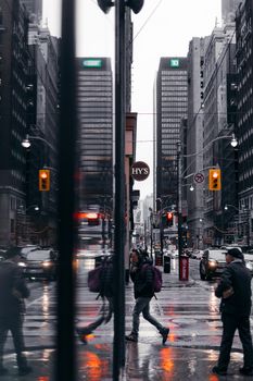 Pedestrians with umbrellas on a rainy Toronto street, reflecting urban life.