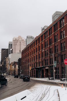 A snowy city street with cars and buildings in a winter urban setting.