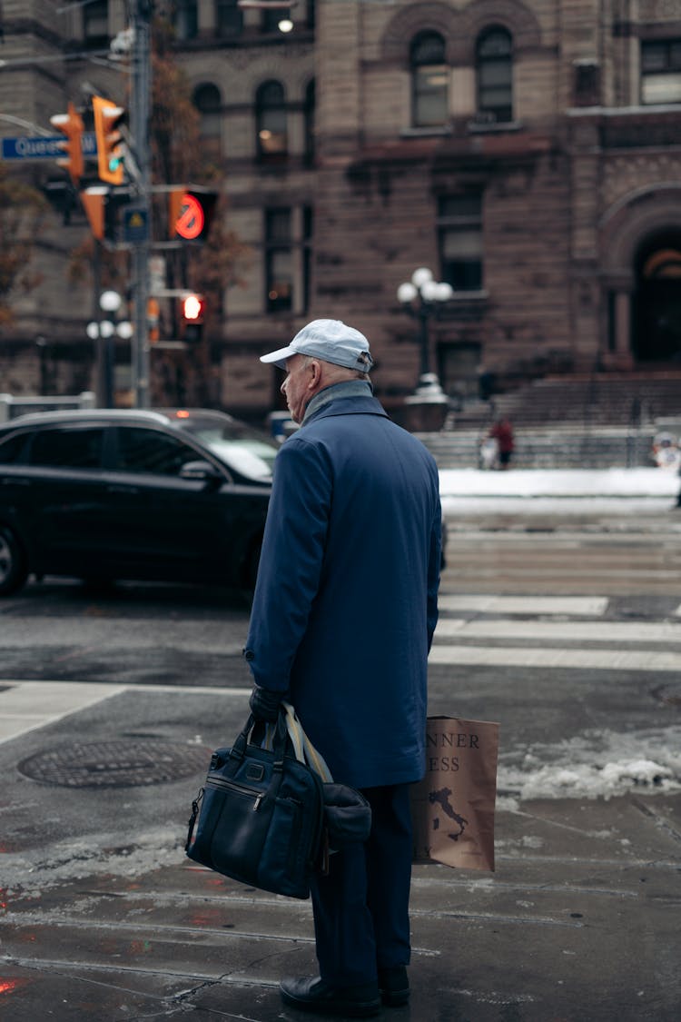 Man Standing On City Street And Holding Bags