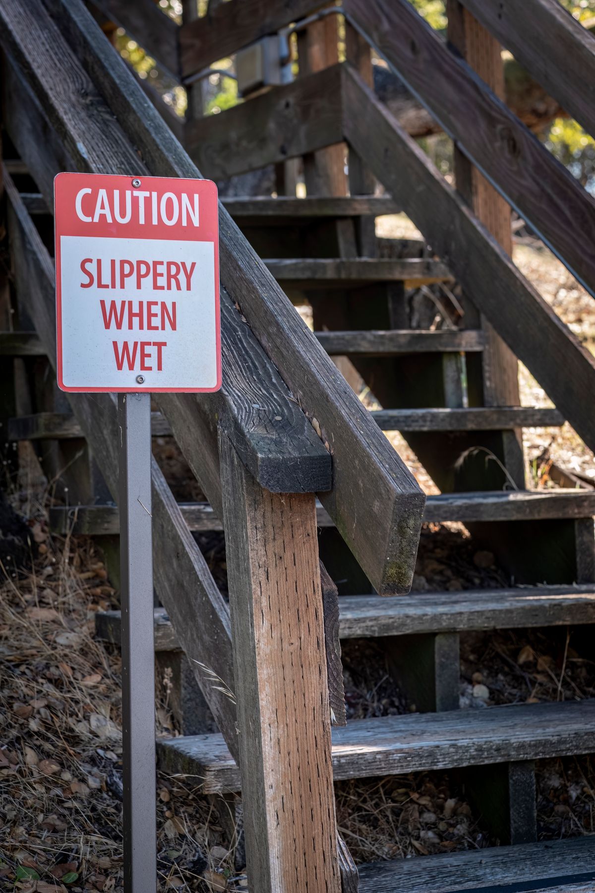 Warning sign near wooden stairs representing a property hazard