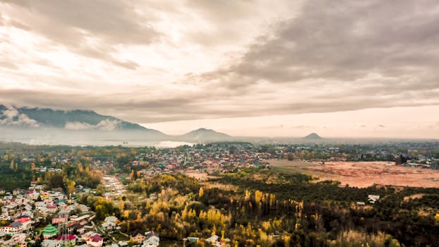 Scenic aerial view of a sprawling cityscape set against a dramatic mountain backdrop.
