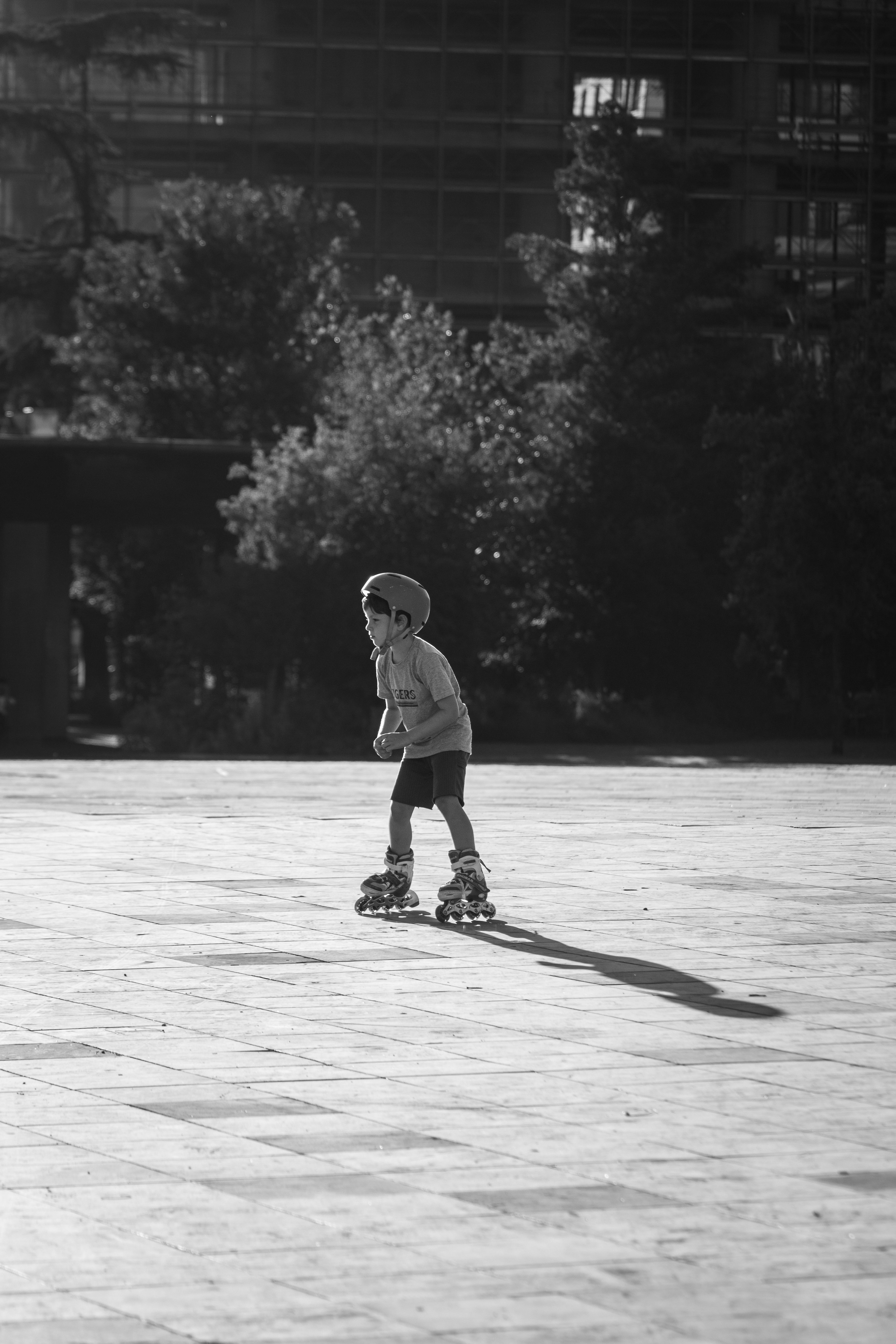 A boy rollerblading in a park, creating a dynamic childhood moment in black and white.