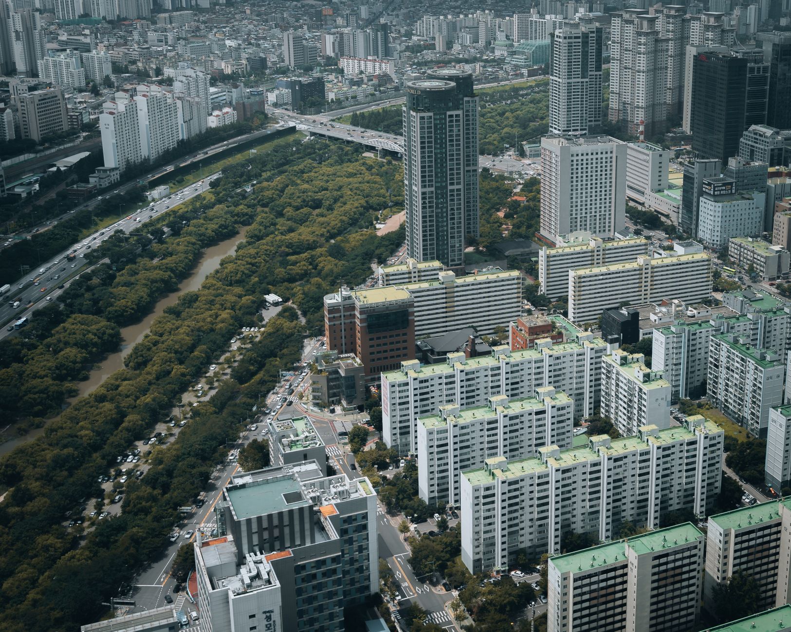 Aerial view of modern skyscrapers and lush greenery in Seoul, South Korea.