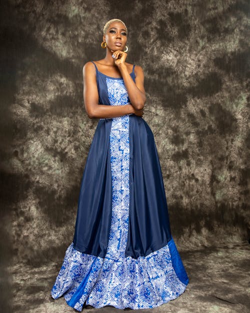 Woman in Blue Sleeveless Dress Posing with Hand on Chin